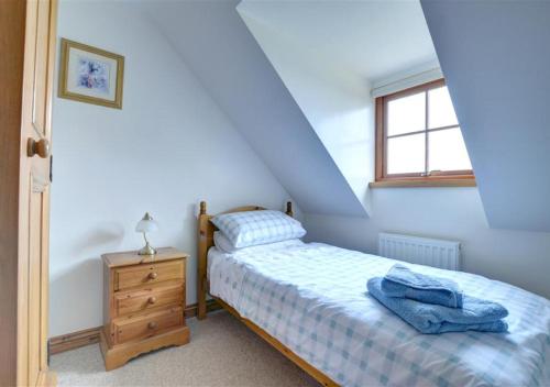 een kleine slaapkamer met een bed en een raam bij Westlands Cottage in Mickleby