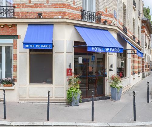 a hotel de paris store with blue awnings on a street at Hotel De Paris in Boulogne-Billancourt