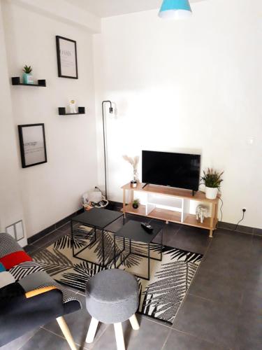 een woonkamer met een tv en een tafel bij T2 Rungis Mermoz Lenôtre Orly in Rungis