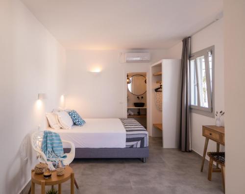 a small bedroom with a bed and a table at Ammos Sifnos Village in Platis Yialos Sifnos