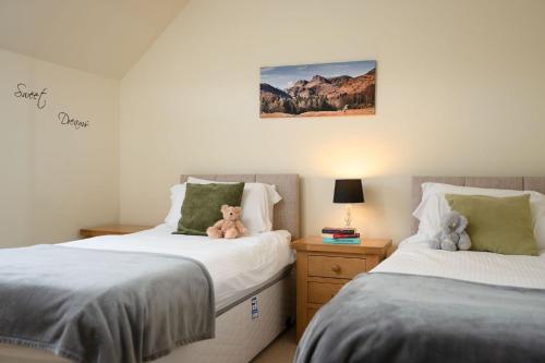 a bedroom with two beds with teddy bears on them at Bracken House in Aviemore