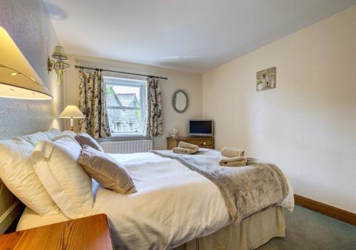 Un dormitorio con una cama grande y una ventana en West Cottage en Thwaite