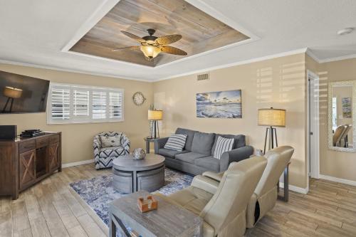 a living room with a couch and a ceiling fan at Island House Beach Resort 25 in Point O'Rocks