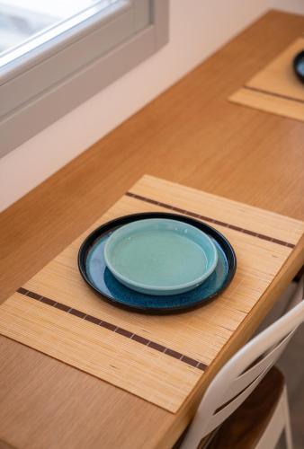 a blue plate sitting on top of a wooden table at Ammos Sifnos Village in Platis Yialos Sifnos