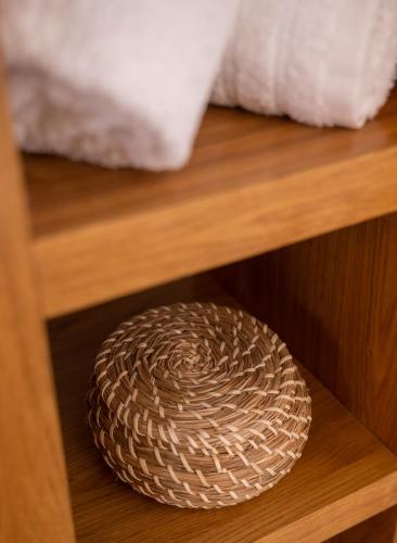 a wooden table with a rattan bowl on it at Ammos Sifnos Village in Platis Yialos Sifnos