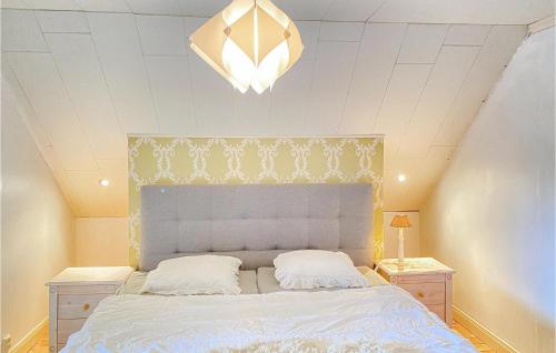 sypialnia z łóżkiem i żyrandolem w obiekcie Cozy Home In Klintehamn With Wifi w mieście Klintehamn