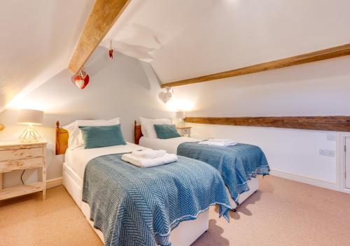 two twin beds in a room with white walls at Alice Cottage in Whitby