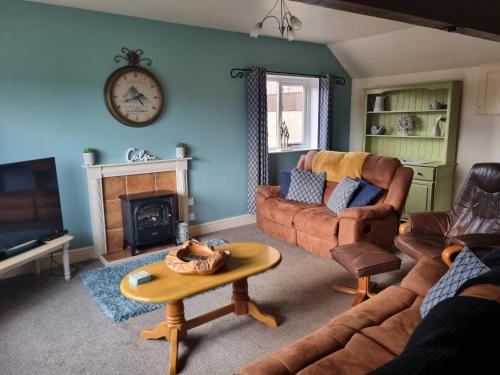 a living room with a couch and a fireplace at Osprey Meadow Holiday Cottages in Bedale