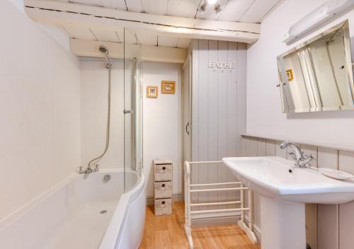 bagno con vasca, lavandino e doccia di Alice Cottage a Whitby