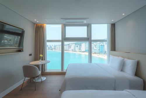 a hotel room with a bed and a large window at Hotel Marine view in Busan