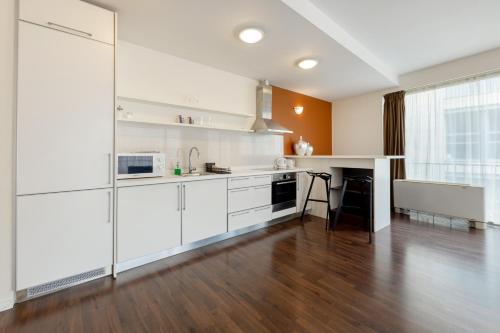 an open kitchen with white cabinets and a table at Bliss Residence & Spa in Budapest
