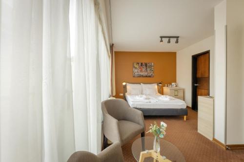 a hotel room with a bed and a table at Bliss Residence & Spa in Budapest