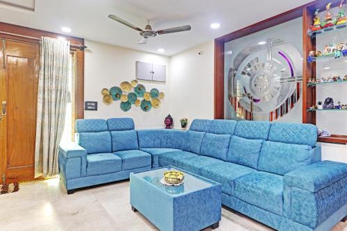 a living room with a blue couch and a table at Super OYO Flagship Sai Mansion in Hyderabad