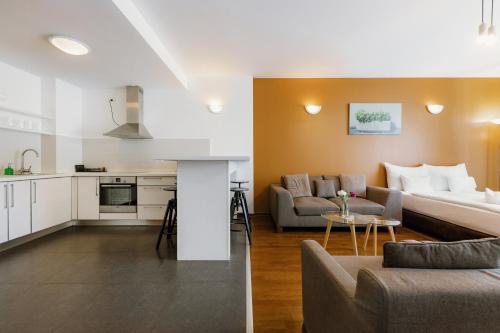 a living room and kitchen with a couch and a table at Bliss Residence & Spa in Budapest