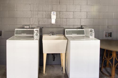 two washing machines sitting next to a sink at Hualalai 307 Thirty One Day Minimum in Hilo