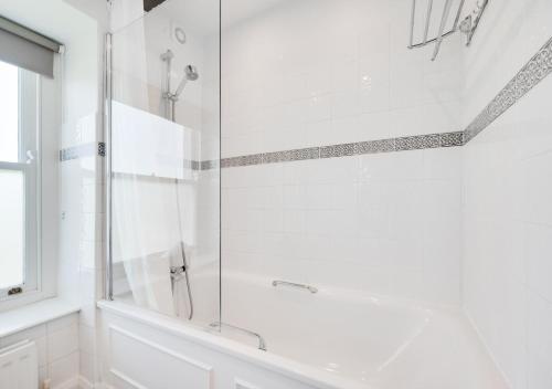 a white bathroom with a glass shower door at Amblers at Two Riverdale in Bainbridge