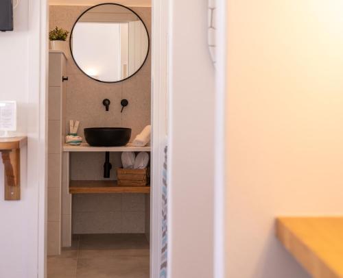 a bathroom with a sink and a mirror at Ammos Sifnos Village in Platis Yialos Sifnos