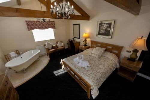 a bedroom with a bed and a tub and a sink at Kings Croft Hotel in Pontefract