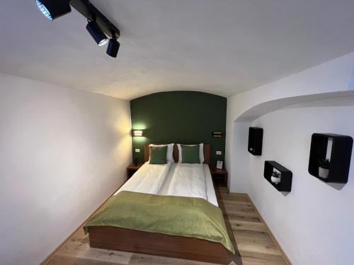 a bedroom with a bed with a green wall at TimHouse in Timişoara