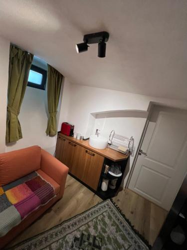 a living room with an orange couch and a mirror at TimHouse in Timişoara