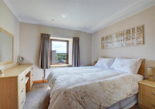 - une chambre avec un grand lit et une fenêtre dans l'établissement Weavers Loft, à Cowling