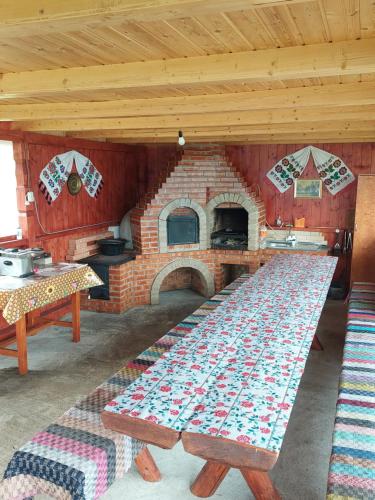 a kitchen with a brick oven with a table in front of it at Cabana Gabriela in Gîrda de Sus