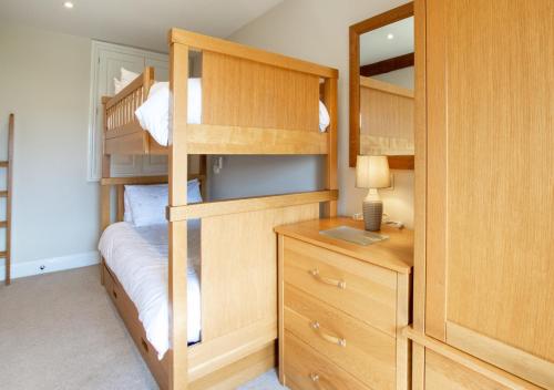 sypialnia z łóżkami piętrowymi oraz biurkiem z laptopem w obiekcie Weavers Cottage w mieście Cowling