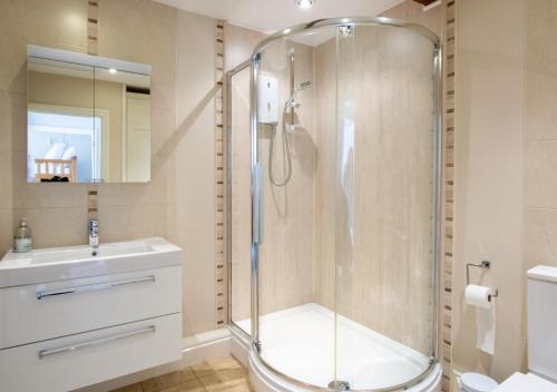 W łazience znajduje się prysznic i umywalka. w obiekcie Weavers Cottage w mieście Cowling