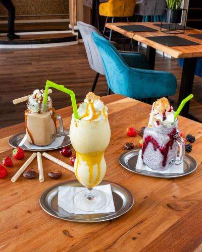 a wooden table with three desserts on plates at Ferienwohnung Marktblick Goslar in Goslar