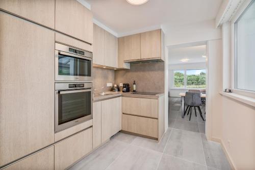 a kitchen with wooden cabinets and a table with a chair at maison des dunes in Ostend