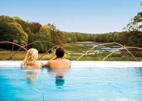 Un hombre y una mujer sentados en una piscina en Eriksberg Hotel & Nature Reserve, en Trensum