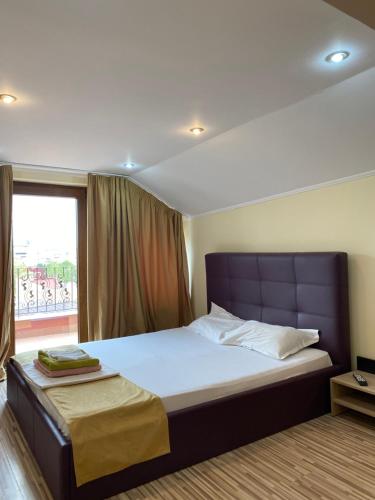 a bedroom with a large bed with a window at Apartament Central in Constanţa