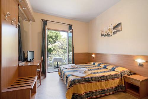 Una habitación de hotel con una cama, un escritorio y una ventana. en Appartamento Bilocale Moneglia 31, en Moneglia