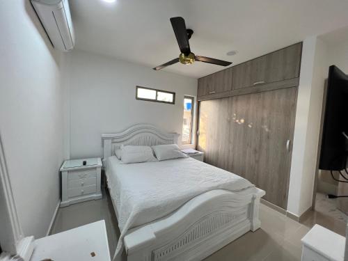 sypialnia z białym łóżkiem i wentylatorem sufitowym w obiekcie Hermoso apartamento central w mieście Montería