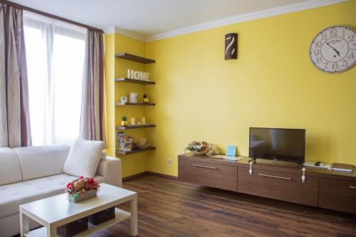 a living room with a white couch and a tv at Golden apartman in Gyula