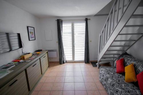un salon avec un escalier et une chambre avec un canapé dans l'établissement La Maisonnette YourHostHelper, à Gruissan