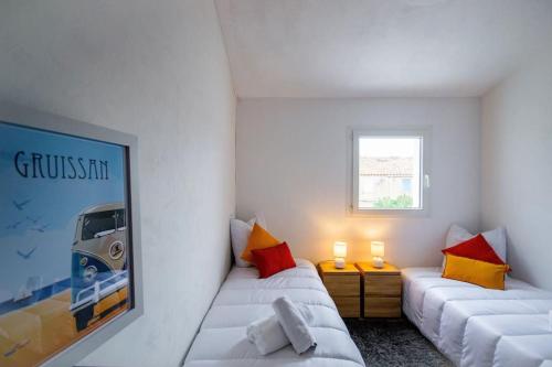 Cette chambre blanche dispose de deux lits et d'une fenêtre. dans l'établissement La Maisonnette YourHostHelper, à Gruissan