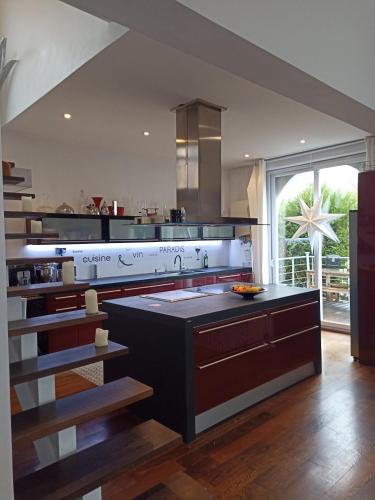 - une grande cuisine avec une grande île dans l'établissement Chambres d'Hôtes LA PASTOURELLE Royan centre, à Royan