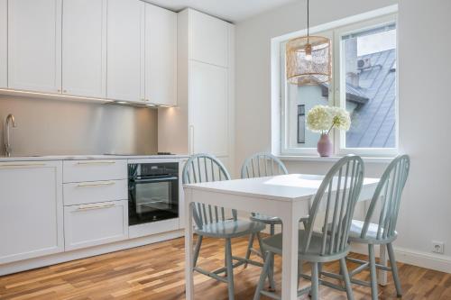 a kitchen with a white table and chairs at Spacious Family Friendly apartment, Free Parking in Tallinn