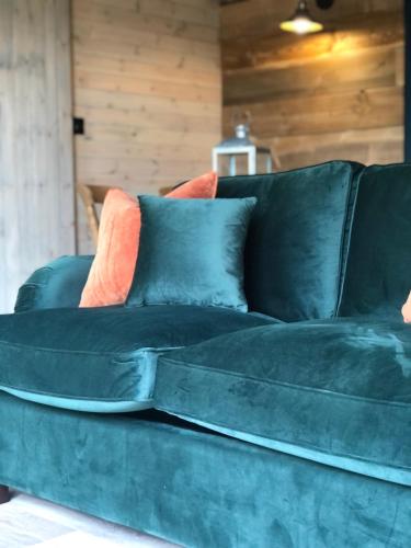 a green couch with some pillows on it at Old Oak Farm in Oakham