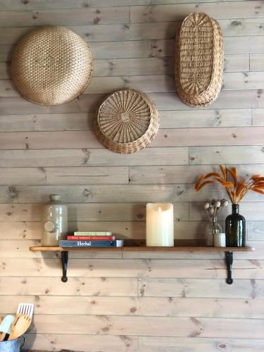 a wall with wicker baskets and a shelf with a candle at Old Oak Farm in Oakham