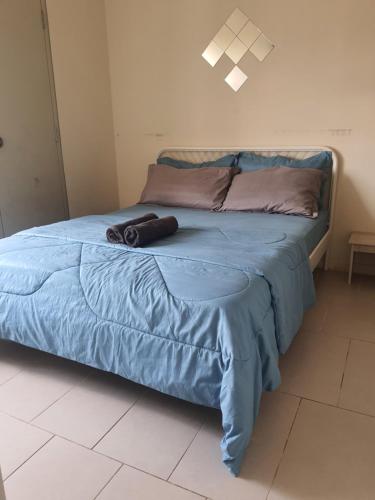 - un lit avec une couette bleue et un sac dans l'établissement Cyberjaya Tamarind Suites,Mediya Homestay, à Cyberjaya