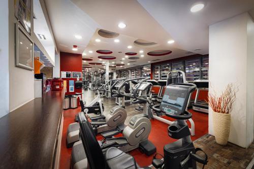 a gym with a bunch of treadmills and machines at Bliss Residence & Spa in Budapest