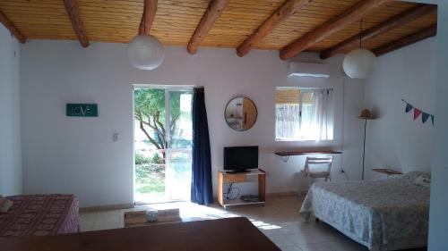 1 dormitorio con 1 cama, TV y ventana en CasaNorte Hospedaje en Miraflores, Catamarca 