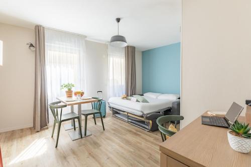 een woonkamer met een bed en een tafel en stoelen bij Appart'City Classic Valence in Valence