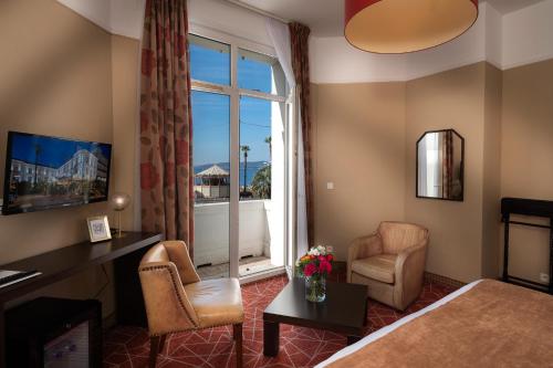 een hotelkamer met een bed en een raam bij Excelsior in Saint-Raphaël