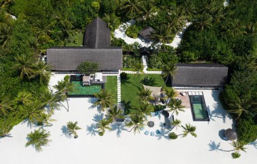 an aerial view of a villa with a swimming pool and palm trees at One&Only Reethi Rah in Reethi Rah