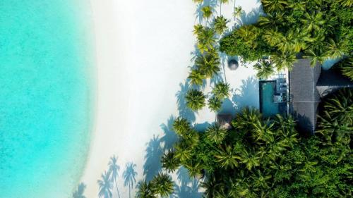 an aerial view of a resort with palm trees and the ocean at One&Only Reethi Rah in Reethi Rah