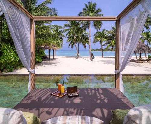 a room with a view of the beach and the ocean at One&Only Reethi Rah in Reethi Rah