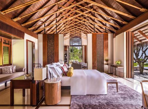 a bedroom with a bed and a living room at One&Only Reethi Rah in Reethi Rah